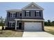 Charming two-story home with gray siding, brick accents, black shutters, and a pristine white garage door at 164 E Victory View. Ter, Smithfield, NC 27577