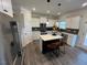 Bright kitchen with a stainless steel refrigerator, island, granite countertops, and white cabinets at 164 E Victory View. Ter, Smithfield, NC 27577