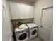 Convenient laundry room with white cabinets and modern appliances at 164 E Victory View. Ter, Smithfield, NC 27577