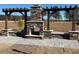 Stone fireplace with seating and wooden pergola for elegant outdoor relaxation and backyard aesthetics at 164 E Victory View. Ter, Smithfield, NC 27577