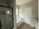 Modern bathroom with glass shower, bathtub, and sleek black hardware at 172 Royal Ave, Selma, NC 27576