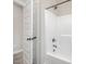 Shower and tub combination in a bathroom with modern fixtures and a tiled floor at 172 Royal Ave, Selma, NC 27576