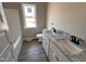 Bathroom featuring double sink with granite countertops and wood-look flooring at 172 Royal Ave, Selma, NC 27576