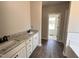 Bathroom featuring double sinks with granite countertops, white cabinets, and hardwood floors at 172 Royal Ave, Selma, NC 27576