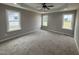 This airy bedroom features a tray ceiling, a ceiling fan, and large windows for abundant light at 172 Royal Ave, Selma, NC 27576