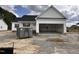New construction single-Gathering home featuring white siding, an open garage, and a gray dumpster in the front yard at 172 Royal Ave, Selma, NC 27576