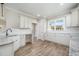 Bright kitchen featuring white cabinets, granite counters, and stainless steel faucet at 172 Royal Ave, Selma, NC 27576