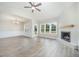 Spacious living room featuring a fireplace, ceiling fan, and large windows offering a scenic view at 172 Royal Ave, Selma, NC 27576