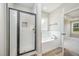 Main bathroom featuring glass shower and white soaking tub with tile surround at 172 Royal Ave, Selma, NC 27576