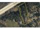 Aerial view of parcels including a house on a lot with trees. Near to the road with industrial or commercial business nearby at 1823 E Geer St, Durham, NC 27704