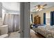 View of a bathroom with shower/tub and bedroom with ceiling fan in background at 1823 E Geer St, Durham, NC 27704