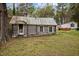 Rustic cabin with a weathered door and windows, nestled in a serene and overgrown landscape at 1823 E Geer St, Durham, NC 27704