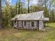 Rustic log cabin featuring aged siding and a weathered tin roof, adding to its vintage charm at 1823 E Geer St, Durham, NC 27704