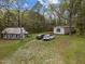 Exterior view featuring a mobile home and a rustic cabin surrounded by trees at 1823 E Geer St, Durham, NC 27704