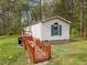Angle exterior of the side and rear of a manufactured home with red porch and walkway at 1823 E Geer St, Durham, NC 27704