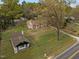 Estate including a stone cottage, an additional small home, tall trees, and gravel driveway at 1823 E Geer St, Durham, NC 27704