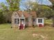 Charming stone cottage with a red-brick chimney and matching stairs leading to a covered front porch entrance at 1823 E Geer St, Durham, NC 27704