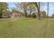 Wide shot of a stone home and the expansive front lawn at 1823 E Geer St, Durham, NC 27704