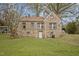 Rear view of a stone home featuring a grassy backyard and access to the basement at 1823 E Geer St, Durham, NC 27704