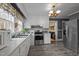 Traditional-style kitchen features white cabinetry, stainless steel appliances, and durable vinyl flooring at 1823 E Geer St, Durham, NC 27704