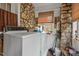 Rustic laundry room with stone accents and a vintage washer and dryer at 1823 E Geer St, Durham, NC 27704