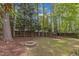 Lush backyard features a cozy stone fire pit and shade trees for outdoor enjoyment at 2002 Patapsco Dr, Apex, NC 27523