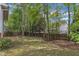 Spacious backyard featuring mature trees, a wooden fence, and an inviting fire pit area at 2002 Patapsco Dr, Apex, NC 27523