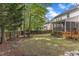 Spacious backyard featuring mature trees, a wooden fence, and an inviting fire pit area at 2002 Patapsco Dr, Apex, NC 27523