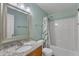 Bright bathroom featuring granite countertop, framed mirror, and shower and tub with curtain and tile surround at 2002 Patapsco Dr, Apex, NC 27523