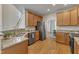 Spacious kitchen featuring stainless appliances, granite counters, wood floors and cabinets, and modern sink fixtures at 2002 Patapsco Dr, Apex, NC 27523