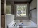 Bright bathroom featuring a soaking tub beneath a window with a treed outdoor view at 2012 Longmont Dr, Wake Forest, NC 27587