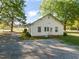 Rear exterior of the home, with a gravel driveway and a well-maintained backyard at 206 Mansfield Dr, Broadway, NC 27505