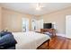 A sunlit bedroom features a ceiling fan, hardwood floors and multiple access doors at 206 Mansfield Dr, Broadway, NC 27505