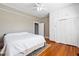 Bright bedroom features hardwood floors, ceiling fan, closet and white bedding at 206 Mansfield Dr, Broadway, NC 27505