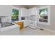Well-lit kitchen with white cabinets and views of the surrounding trees at 206 Mansfield Dr, Broadway, NC 27505