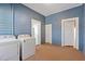 Laundry room with washer, dryer, blue paneled walls and two entry ways to other rooms at 206 Mansfield Dr, Broadway, NC 27505