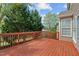 A stained-wood back deck offers outdoor living space near green trees and a home's window at 211 Kurtner Ct, Morrisville, NC 27560