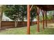 A lush backyard view shows wood posts, grass, a mulch bed and a tall wood fence at 211 Kurtner Ct, Morrisville, NC 27560
