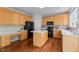 Charming kitchen featuring wooden cabinets, black appliances, and a kitchen island at 211 Kurtner Ct, Morrisville, NC 27560
