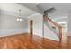 Spacious living room featuring hardwood floors, staircase with white railing, and a neutral color palette at 211 Kurtner Ct, Morrisville, NC 27560