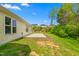 Backyard of home featuring concrete patio in the grass, a portion of siding, and some trees at 223 Triumph Dr, Elon, NC 27244
