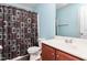 Bathroom features blue walls, vanity with wooden cabinets, white sink, toilet, and shower with patterned curtain at 223 Triumph Dr, Elon, NC 27244