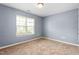 A serene bedroom with neutral carpet and a window with natural light at 223 Triumph Dr, Elon, NC 27244