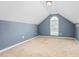 A spacious bedroom with neutral carpeting and a unique arched window at 223 Triumph Dr, Elon, NC 27244