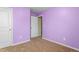 Bedroom featuring neutral carpeting, purple painted walls, and white doors at 223 Triumph Dr, Elon, NC 27244