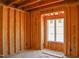 Unfinished bedroom with wood framing featuring a white framed window allowing natural light at 2328 Ballywater Lea Way, Wake Forest, NC 27587