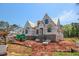 View of a new two-story home under construction, showcasing its exterior with wrappings and a brick base at 2328 Ballywater Lea Way, Wake Forest, NC 27587