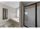 Bathroom with a shower featuring a glass door and a separate soaking tub near a window at 24 Kaki Ct, Selma, NC 27576