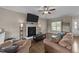 Comfortable living room featuring a fireplace, ceiling fan, and wood-look flooring at 24 Kaki Ct, Selma, NC 27576