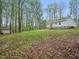 Serene backyard with a white home and a lush green lawn surrounded by mature trees at 25 Beechnut Ct, Franklinton, NC 27525